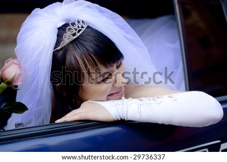 pretty bride with rose in car