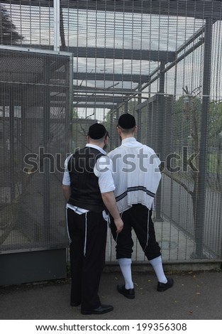 LONDON, ENGLAND - JUNE 07, 2014: Jewish men view the bird cage in a local park. Jews live in almost every county and district in Great Britain 96.7% lived in England, 2.5% in Scotland, 0.8% in Wales