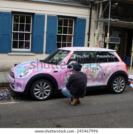 LONDON, ENGLAND - OCTOBER 16, 2014: Artist makes abstract art on a car on the street in London, England