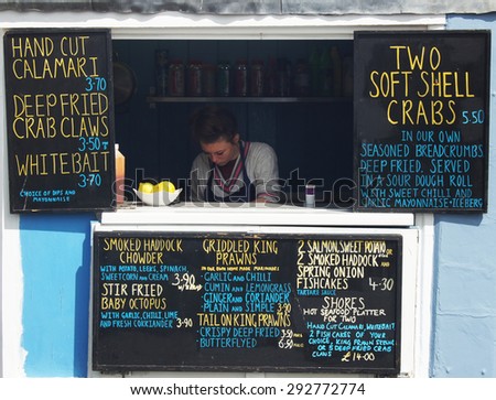 HASTINGS, UK - MAY 04, 2015: Busy staff works in a small seafood shop during the Jack the Green festival in Hastings,UK.