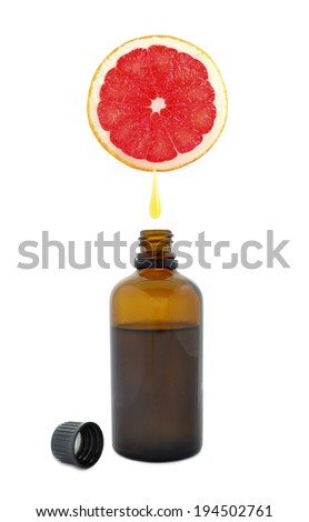 Fresh grapefruit oil flowing from grapefruit into the bottle