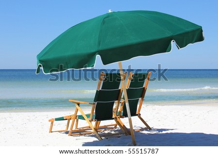 two chairs and umbrella on white sand beach