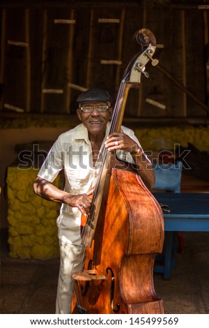 HAVANA - FEBRUARY 2: Old man plays the contrabass February 2, 2013 in Havana, Cuba. Cuban music is an attraction for the over 2 million tourists who go to Cuba each year.