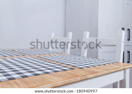 View of a rustic kitchen table with white chairs