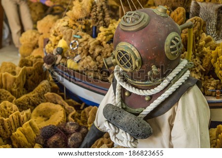A vintage diving suit with helmet with natural sponges in the background, Greece