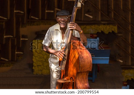 HAVANA - FEBRUARY 2: Old man plays the contrabass February 2, 2013 in Havana, Cuba. Cuban music is an attraction for the over 2 million tourists who go to Cuba each year.