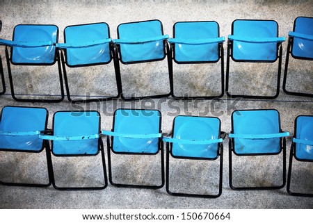 There are many blue chairs in school hall.