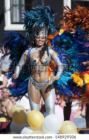 AMSTERDAM, THE NETHERLANDS - AUGUST 3, 2013: Sexy lady With with colored feathers  dance in front of spectators at the  Canal Parade of the Amsterdam Gay Pride 2013 on August 3, 2013 in Amsterdam