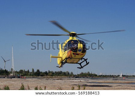 MEDEMBLIK ,NETHERLANDS - AUGUST 12, 2013: Medical dutch rescue helicopter that just takes off  on AUGUST 12 ,2012 in Medemblik, Netherlands.