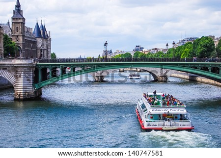 PARIS, FRANCE - JUNE 7: Seine, bridge Notre-Dame, and tourist boat, on June 7, 2009 in Paris, France. Les Halles area contains one of the largest underground modern shopping precincts in Paris.