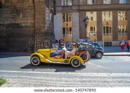 PRAGUE, CZECH REPUBLIC - JUNE 13: Sightseeing tourists in yellow retro car, on June 13, 2009 in Prague, Czech Republic.
