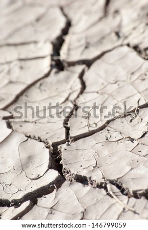 Cracked lifeless soil drying under ardent sun, macro
