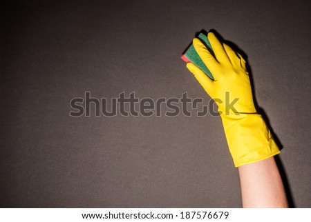Female hand holding sponge with foam against black background