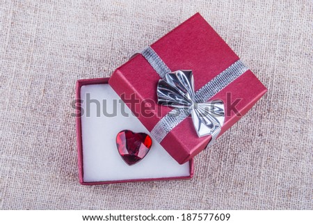 opened red gift box with jewel in form of heart