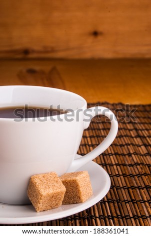 espresso in white cup with brown sugar on table covered with wooden mat