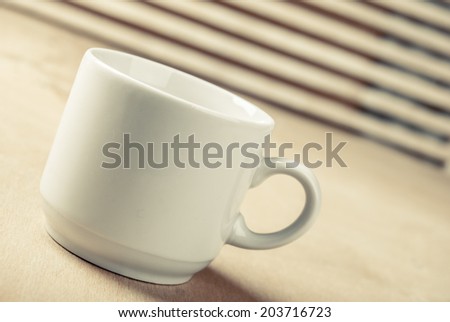 white ceramic cup of coffee on wooden table