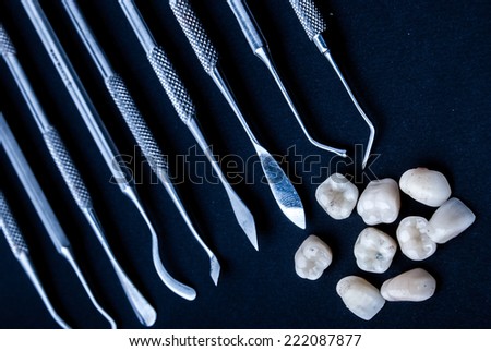 close up dental instruments and false teeth on black background