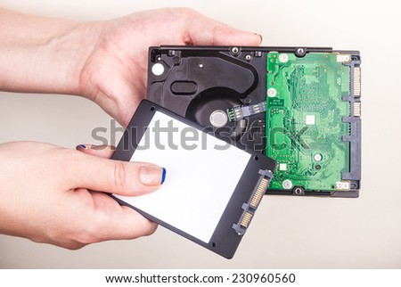 Female hand showing a Solid State Drive on white