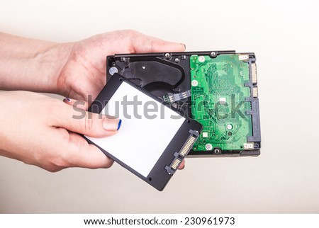 Female hand showing a Solid State Drive on white
