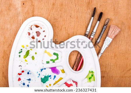 Wooden art palette with blobs paint and brushes Vector Image