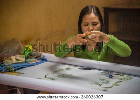HOI AN, VIETNAM - FEBRUARY 5, 2015: Vietnamese woman produces hand-made embroidery, in Hoi An, Feb 5, 2015.
