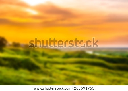 Sunset in countryside. Colorful landscape with trees, hills, river and cloudscape