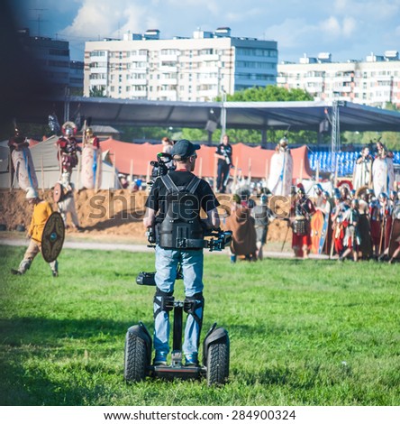 MOSCOW - JUNE 06, 2015: Cameraman on Steadiseg shooting historical reenactment in Kolomenskoye, Moscow. Steadiseg is easy way to capture smooth tracking shots at a fairly brisk pace.