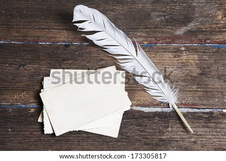 old letters and a quill on vintage wood