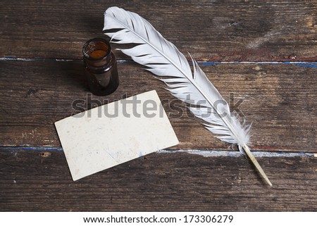 old letters, ink bottle and a quill on vintage wood