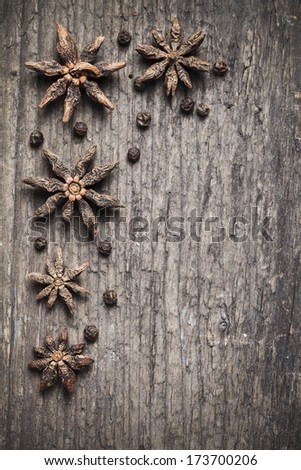 star anise and black peppercorns on aged wood