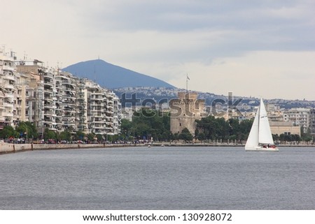City at the sea with big buildings, landmark tower and sailing boat