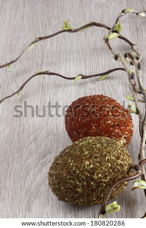 Easter decorations / cards hand-decorated easter eggs covered in spices and couscous with willow sticks on a wooden background / on the table
