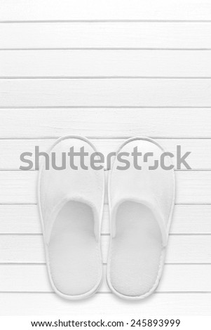 White hotel / home/ spa / wellness slippers with towel on light wood desk with space for text - summer sauna time