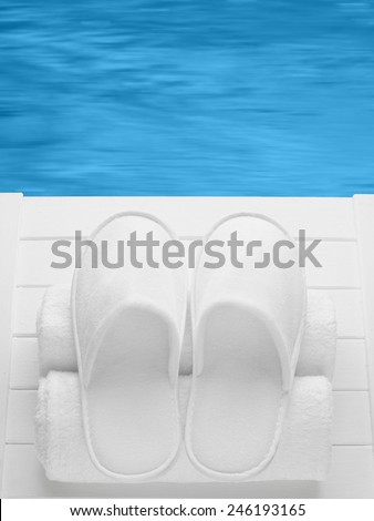 Balneo, spa, hotel, home, wellness slippers with rolled towels on pier with water background - summer, sauna time - space for text