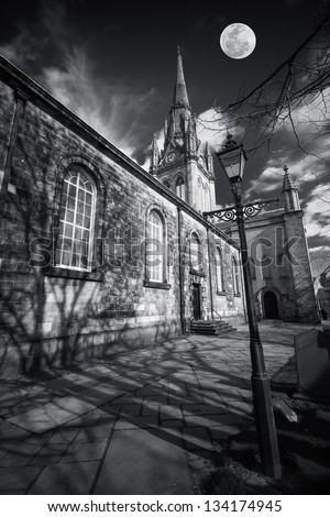 Gothic church in shadowy black and white with moon above - composite