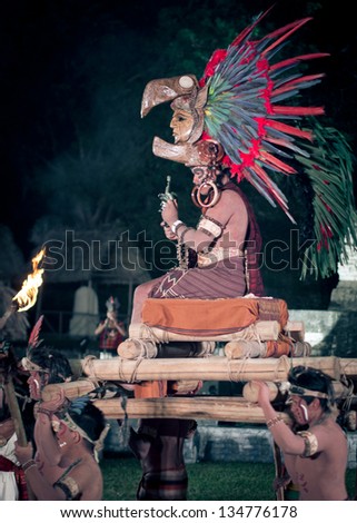 TIKAL, GUATEMALA - DECEMBER  21: A man dressed in traditional Mayan costume is carried on a platform on December 21, 2012 at Tikal, guatemala.  Part of the 2012 Mayan new year celebrations.
