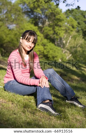 Cute girl in a field of lushy grass thinking of someone