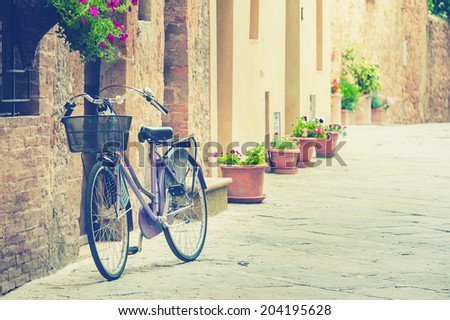 Lonely bike awaiting its owner, based on the old wall in Tuscany, Italy