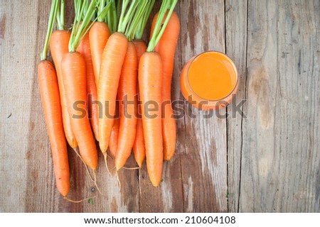 Fresh carrots and juice on a wooden rustic table Vintage
