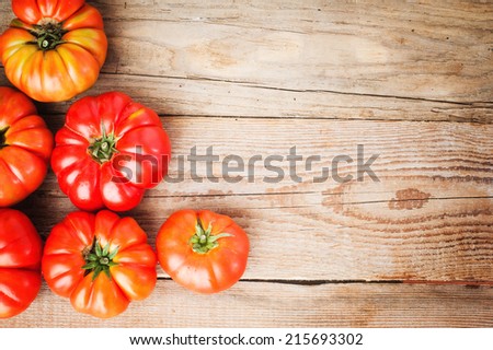 Red big tomatoes on a wooden rustic table in a beautiful day