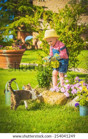 Cute little girl doing garden work between colorful flowers.
