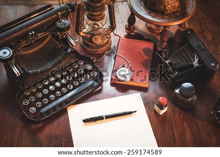 Vintage items, camera, pen, globe, clock, typewriter on the old desk