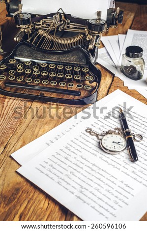 Text prescribed on a vintage typewriter and watch timekeeper.