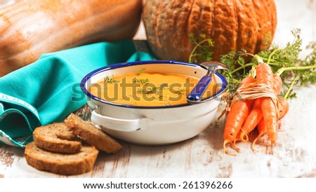 Pumpkin soup with bread crouton on white wood table