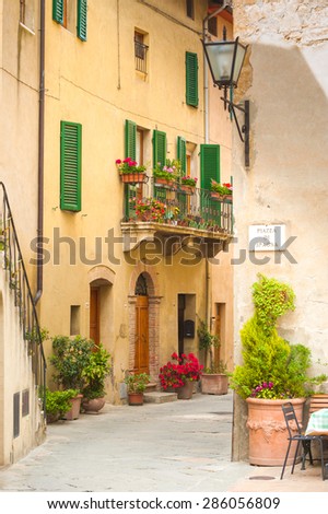 Old alley in the medieval town with flowers, Pienza