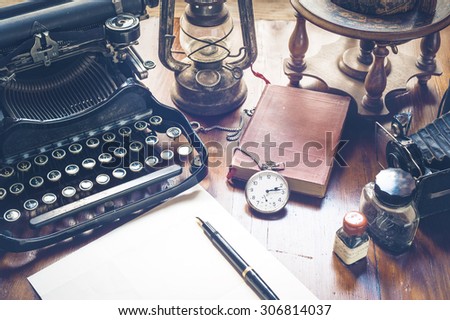 Vintage items, camera, pen, globe, clock, typewriter on the old desk