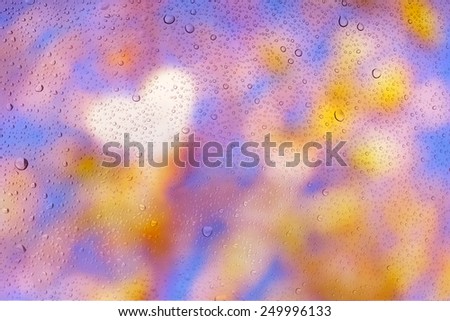 drops of rain on windows heart defocused bokeh lights and natural autumn trees out of focus background