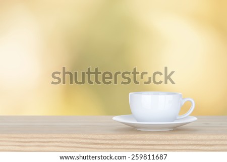 white cup of coffee on pine Wooden Table and bokeh,defocused light background