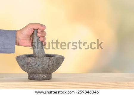hand business man catch pestle mortar on pine and bokeh,defocused light background