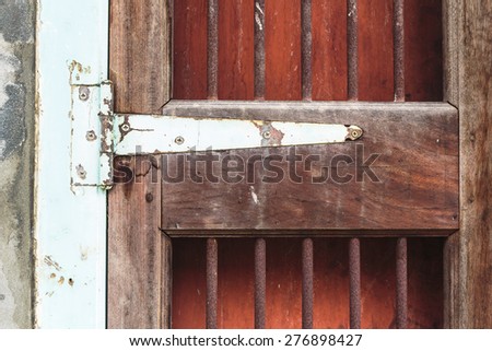A fragment of an old door with a rusty door hinge.